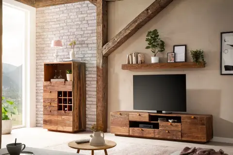 Rustikales Wohnzimmer mit Möbeln aus **Massivholz**, die Wärme und Gemütlichkeit ausstrahlen. Ein TV-Lowboard und ein Schrank mit Weinregal stehen im Fokus.