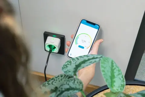 Smart eluttag med timerfunktion för lampor, styrd via mobilapp. Grön indikator visar att strömmen är på.
