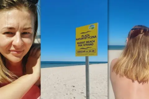 Uśmiechnięta kobieta na plaży nudystów. Obok tablica informująca o obszarze.