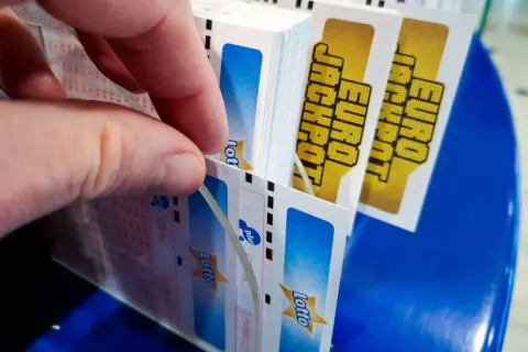 Dłoń wybiera kupony Eurojackpot. Dlaczego w Eurojackpot trudniej trafić siódemkę niż szóstkę w zwykłym Lotto? Więcej liczb do wyboru!