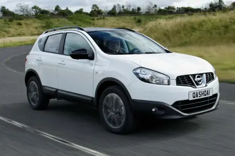 Vit Nissan Qashqai kör på en kurvig väg. En förare syns bakom ratten. Kanske ett problem med bilen?