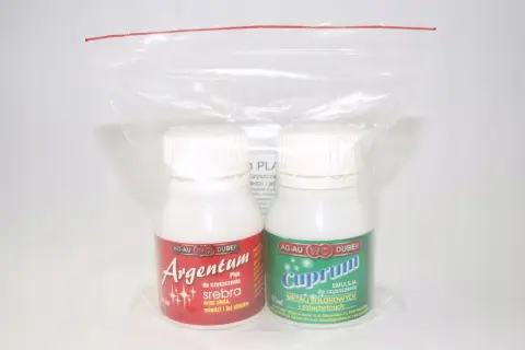 Dwie butelki płynów do czyszczenia: Argentum do srebra i Cuprum do metali kolorowych, w plastikowym opakowaniu.