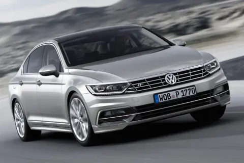Silver Passat GTR glider fram på en väg med berg i bakgrunden.