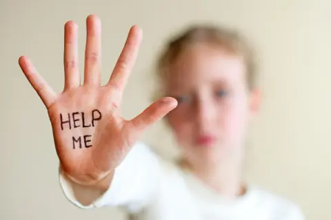 Dłoń dziecka z napisem "HELP ME" symbolizuje trudności, z jakimi mogą borykać się osoby z zespołem hiperkinetycznym, potrzebujące wsparcia.