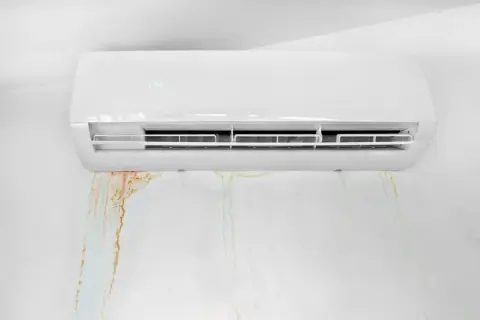 Condizionatore perde acqua nel muro, lasciando macchie di umidità e ruggine.