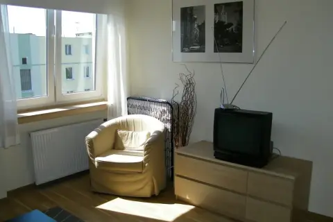 Stary telewizor i fotele, pamiątka po dziadkach, symbolizują dziedziczenie.