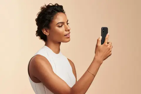 Donna con smartphone, utile per capire come scegliere fondotinta online.