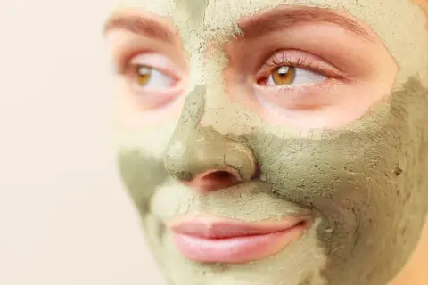 Primo piano di un volto con maschera all'argilla verde. Scopri a cosa serve l'argilla verde per la tua pelle.