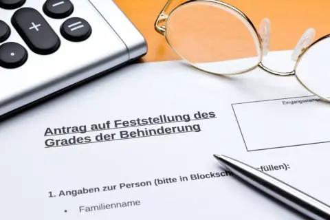Antrag auf Feststellung des Grades der Behinderung, mit Brille, Taschenrechner und Stift. Wichtig für die Einschätzung des osteochondrose behinderungsgrad.