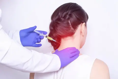 Avis sur infiltration cervicale C5-C6 : un médecin injecte un traitement dans le cou d'une patiente, soulageant une douleur localisée.
