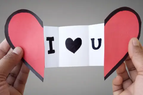 Cuore rosso diviso a metà, con un biglietto che dice "I ♥ U". Un'idea per i san valentino lavoretti fai da te.
