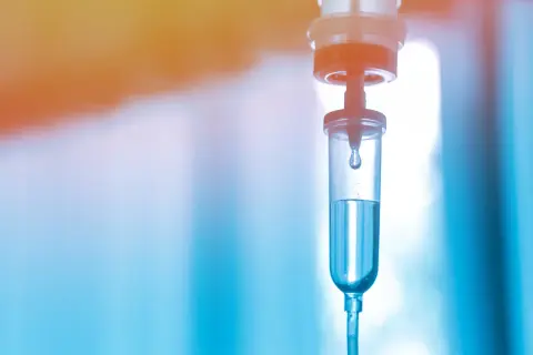 Tropfen für Tropfen fließt die Flüssigkeit in den Tropfbehälter. Ein Hoffnungsschimmer für die Immuntherapie-Infusion.