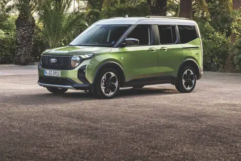 Nowy zielony Ford Tourneo Connect, jeden z wielu ciekawych ford modele, zaparkowany na tle palm.