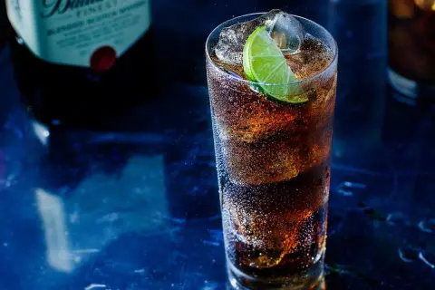 Orzeźwiający drink z whisky i colą, z plasterkiem limonki. Idealny pomysł, z czym pić whisky na wieczór.