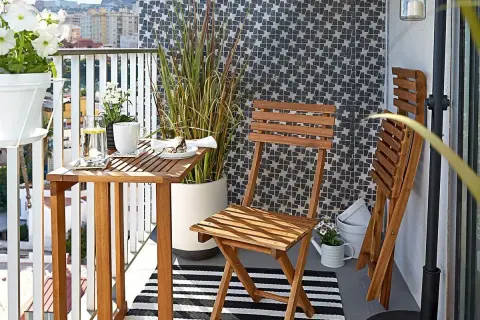 Drewniane meble i wysoka trawa tworzą przytulną atmosferę, idealną, by osłonić balkon od sąsiadów.