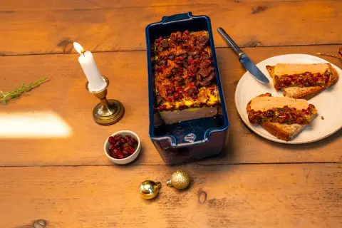Une terrine maison aux airelles, servie sur toasts avec une bougie allumée. Une ambiance festive pour un délice.