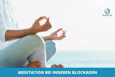 Person meditiert am Strand, um innere Blockaden zu lösen. Hände in Mudra-Geste, Fokus auf Entspannung und Klarheit.
