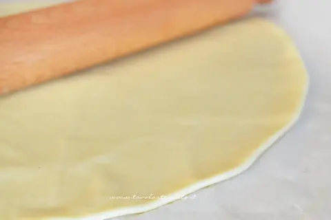 Stesura della pasta brise con un mattarello. L'olio rende l'impasto elastico e facile da lavorare per creare torte salate o dolci.