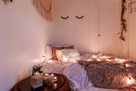 Gemütliches Schlafzimmer mit Lichterkette und Kissen. Tolle geschwister zimmer teilen ideen für eine kuschelige Atmosphäre.