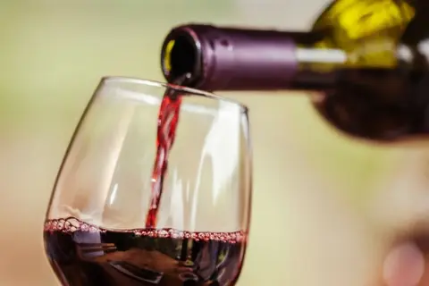 Rotwein wird in ein Glas gegossen. Für Menschen mit Histaminintoleranz ist eine **Histamin Wein Tabelle** hilfreich, um verträgliche Sorten zu finden.