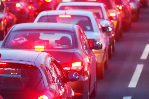 Voitures à l'arrêt dans un embouteillage, leurs feux de position seuls illuminent la route.