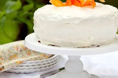 En saftig glutenfri morotskaka med vit frosting och strimlade morötter som dekoration. Perfekt för fikat!