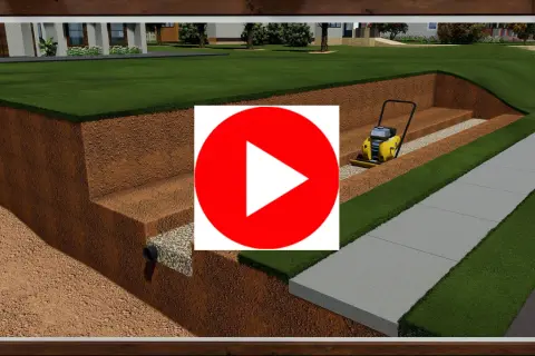 Construcción de un muro de contención con compactadora. Se ve la excavación, drenaje y preparación del terreno para un jardín y acera.