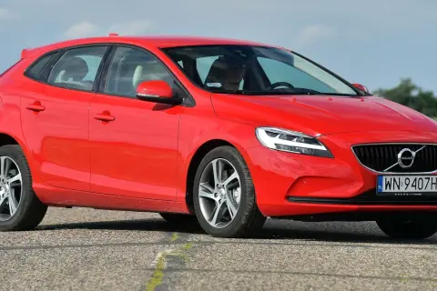 Czerwone Volvo V40 D2 z polskimi tablicami rejestracyjnymi jedzie po asfaltowej drodze.
