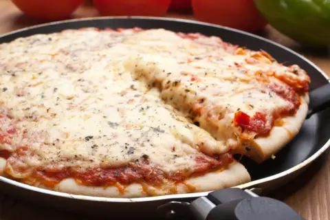 Deliciosa pizza en sartén, con queso derretido y salsa de tomate. Perfecta para compartir.