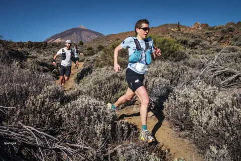 Coureurs en plein effort sur un sentier rocailleux, le Teide en arrière-plan, lors du **Tenerife Bluetrail**.