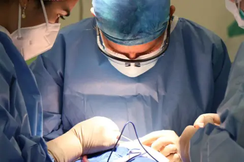 Chirurgen bei einer Schulter-OP. Einblicke in die Behandlung eines Sehnenrisses, die Hoffnung auf Heilung wecken.