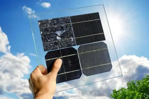 Mano sostiene panel solar con diferentes celdas. ¡Aprovecha la bonificación IBI para placas solares en Castilla-La Mancha!