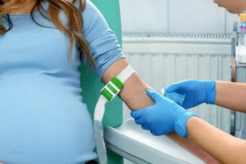 Gravid kvinna får blodprov taget, en del av den vanliga vården som kan komplettera en kub ultraljud.