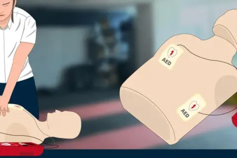 Ćwiczenie RKO z AED. Na manekinie widoczne elektrody AED, sugerujące brak akcji serca (asystolia ekg).