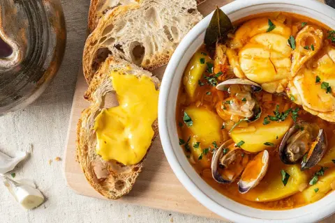 Sopa bullabesa, de origen francés, con mariscos, patatas y pan tostado con alioli.