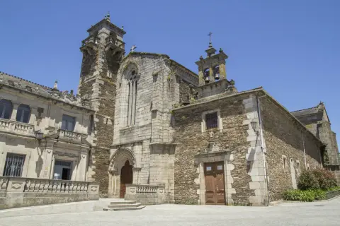 La iglesia de San Pedro de Lugo, con su imponente torre y fachada de piedra, se alza bajo un cielo azul.