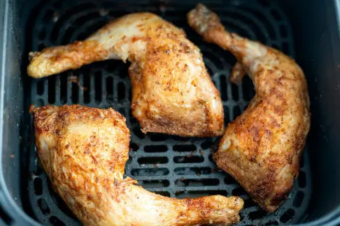 Trozos de pollo dorados y jugosos en la freidora de aire, listos para disfrutar.