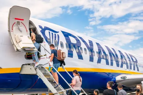 Pasażerowie wsiadają na pokład samolotu Ryanair. Czy Ryanair jest bezpieczny? Tysiące lotów dziennie świadczy o zaufaniu.