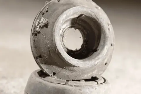 Biellette de barre stabilisatrice usée, cause probable du bruit. Pièce en caoutchouc craquelé et sale.
