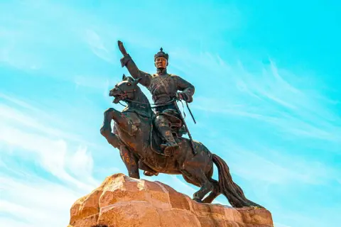 Statue équestre d'un guerrier, symbole de la descendance de Gengis Khan, sous un ciel bleu éclatant.