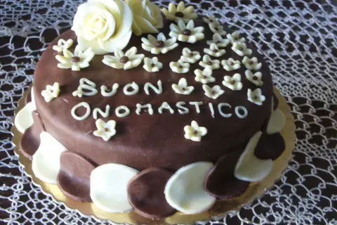 Torta al cioccolato con decorazioni in pasta di zucchero, un augurio speciale: "Buon Onomastico" per un uomo.