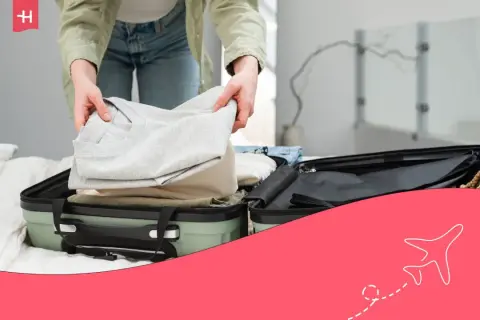 Persona doblando ropa para aprender como hacer una maleta para ahorrar espacio.