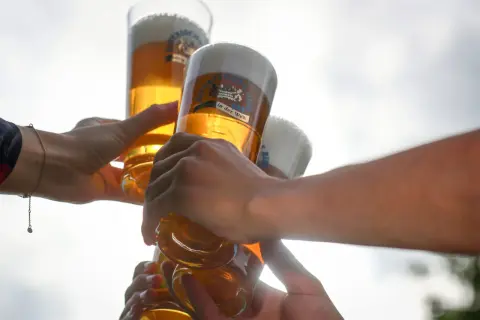 Hände stoßen mit Biergläsern an, ein Moment der Freude bei Bier Events.