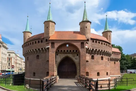 Barbakan w Krakowie, jedna z głównych kraków atrakcje, zaprasza do zwiedzania. Drewniany most prowadzi do zabytkowej budowli.