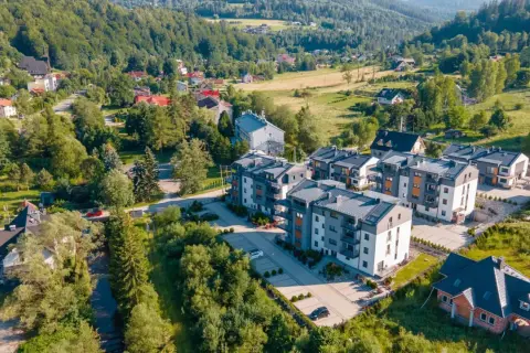 Nowoczesne apartamenty w malowniczym uzdrowisku w Beskidzie Śląskim, otoczone zielenią i górami.