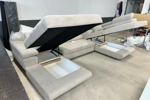 Sofa z systemem rozkładania Delfin, z otwartymi schowkami pod siedziskami.
