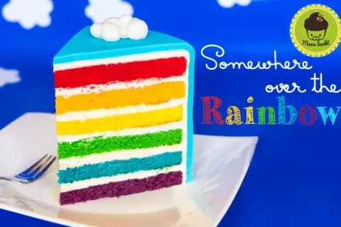 Ein Stück regenbogen kuchen mit bunten Schichten und Wolken-Topping.