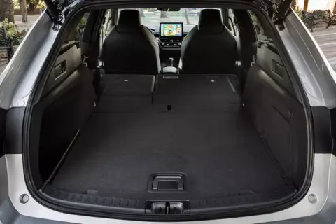 Otwarty bagażnik Toyoty Corolli kombi, z rozłożonymi siedzeniami, pokazuje jego przestronność. Idealny na wakacyjne wyjazdy, gdy liczą się wymiary bagażnika.