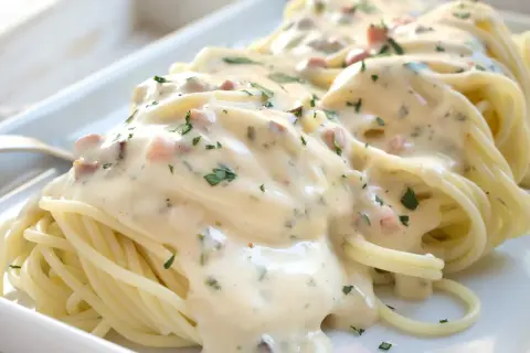 Spaghetti mit cremiger Sauce, Speckwürfeln und Petersilie. Ein köstliches Carbonara Rezept, das zum Genießen einlädt.