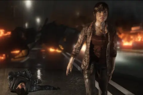 Jodie Holmes stoi na tle płonących samochodów, obok leży nieprzytomny żołnierz. To scena z gry Beyond Two Souls, która pokazuje intensywny czas gry.
